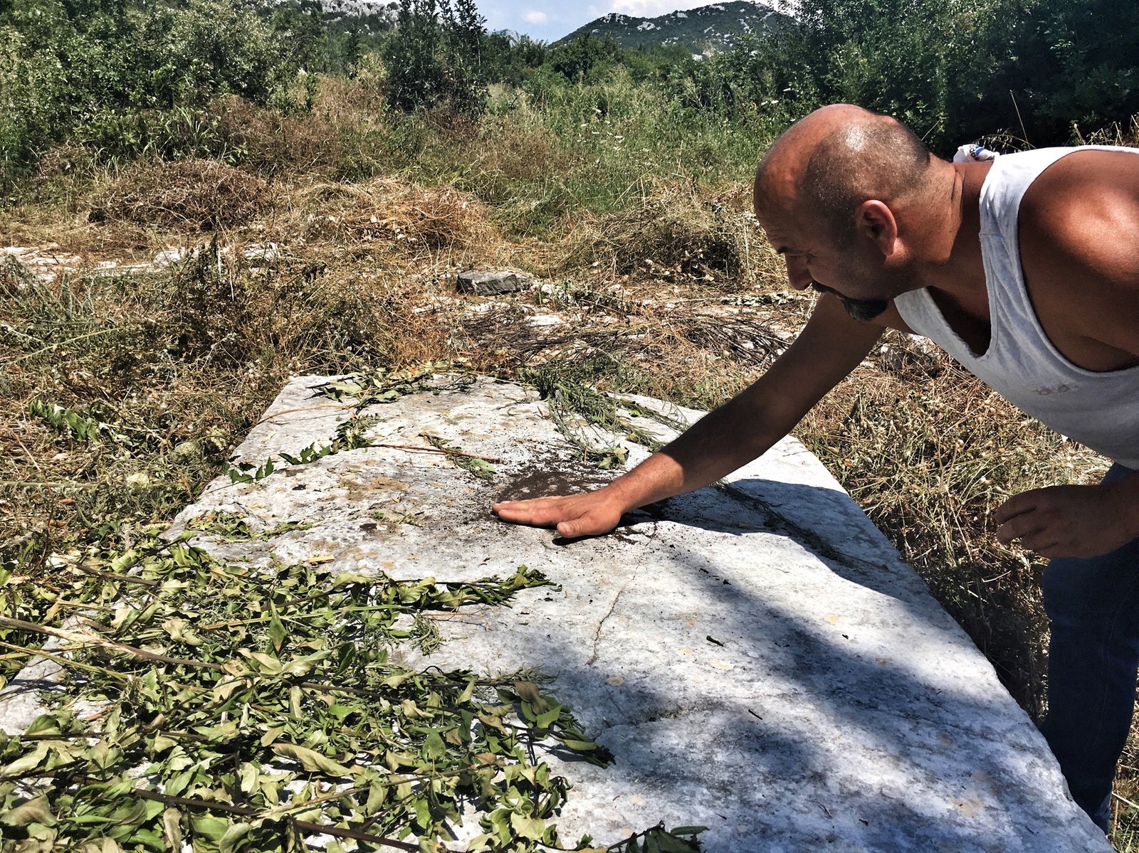 Via Dinarica: Exploring Ravno, Neum, and the Beaches of Bosnia & Herzegovina 18 Local dude showing motif on stecci near Neum, Bosnia & Herzegovina © The Blonde Gypsy