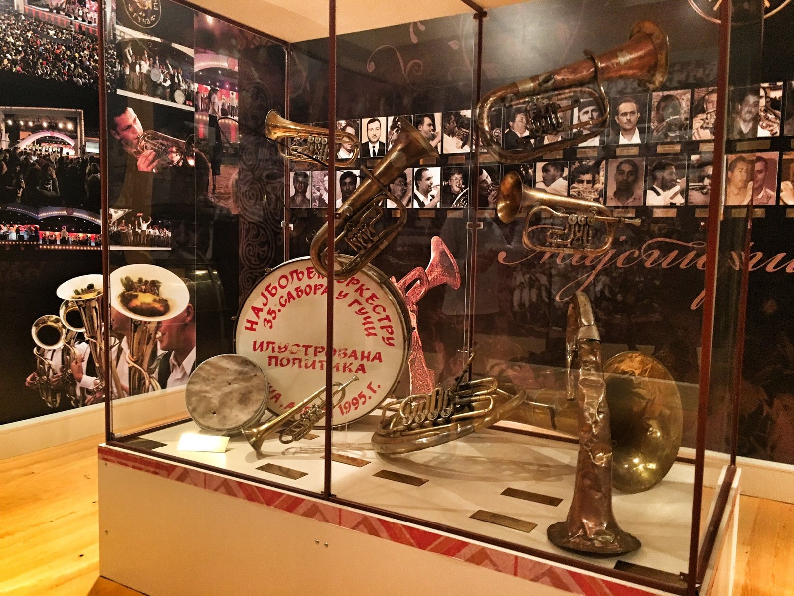 Collection of brass instruments in front of the wall displaying all the festival trumpet champions over the past 55 years