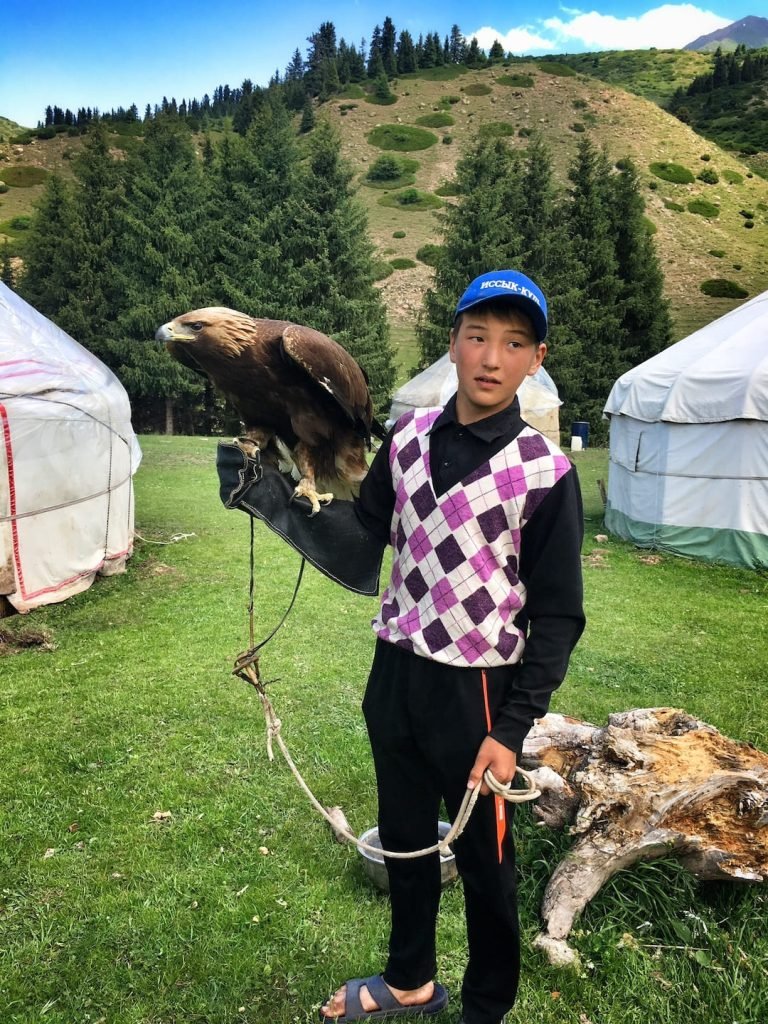 Eagle owner in the Valley of Flowers near Issyk Kul in Kyrgyzstan © larissa olenicoff